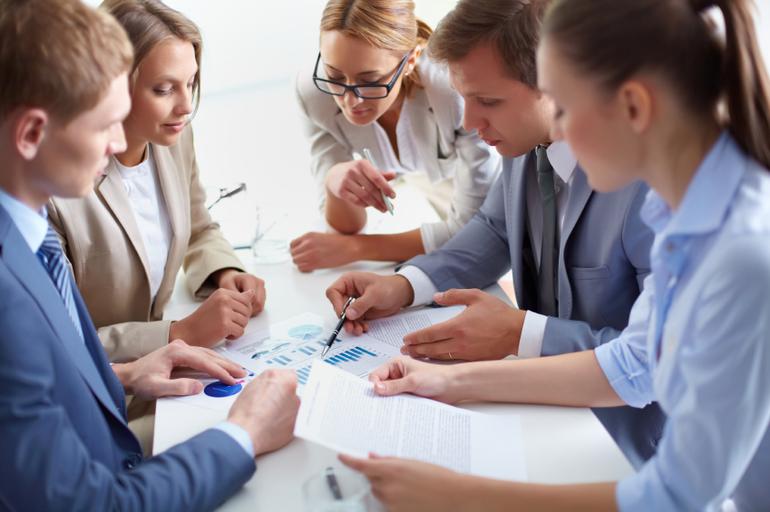 Image of business partners discussing documents at meeting