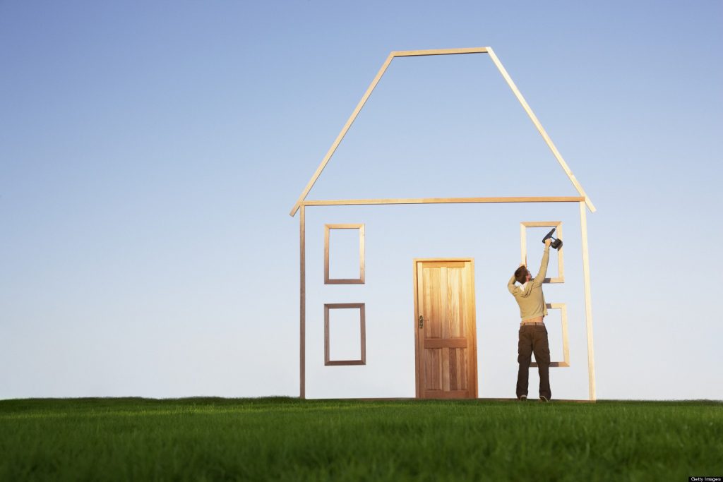 Man using drill on house outline