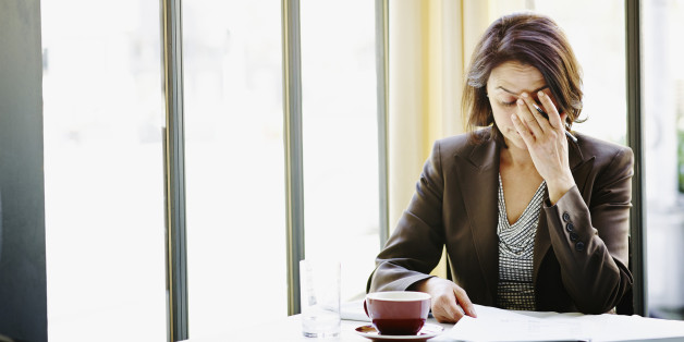 Businesswoman at table with head resting on hand