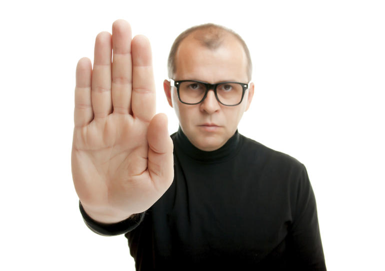 Man in black showing rejective hand gesture, isolated on white