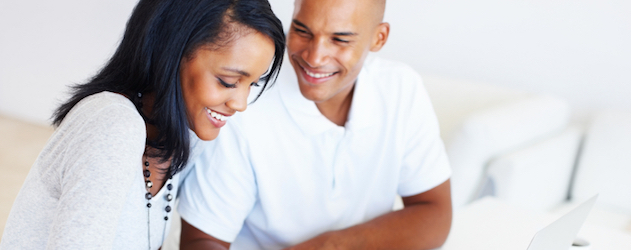 Portrait of young attractive couple calculating their monthly expenses at home